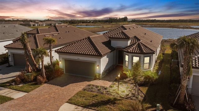 view of front of house with a garage and a water view