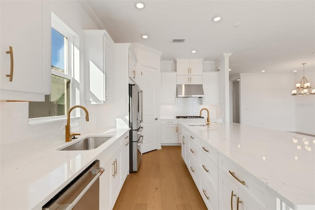 kitchen featuring sink, hanging light fixtures, light stone countertops, appliances with stainless steel finishes, and white cabinets