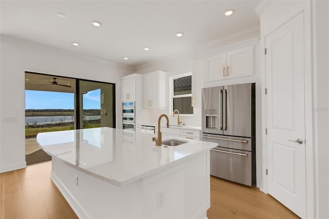 kitchen featuring white cabinets, an island with sink, and stainless steel appliances