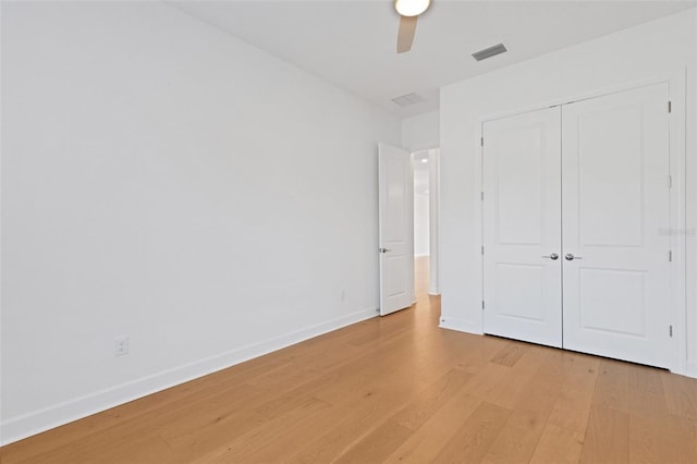 unfurnished bedroom with light wood-type flooring, ceiling fan, and a closet