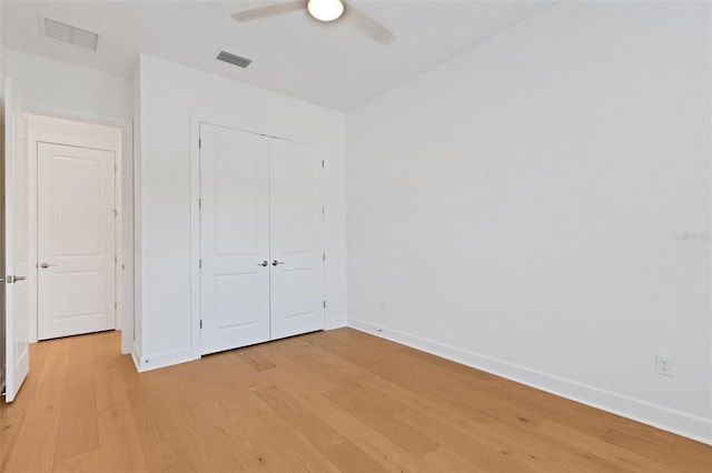 unfurnished bedroom featuring ceiling fan, a closet, and light hardwood / wood-style flooring