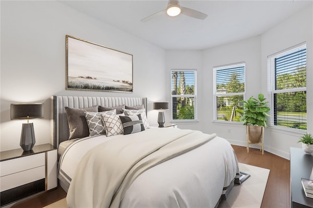 bedroom featuring wood finished floors, baseboards, and ceiling fan