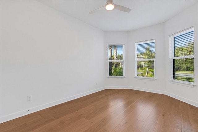 empty room featuring baseboards, wood-type flooring, and ceiling fan