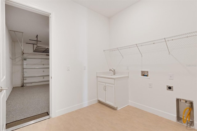 washroom featuring baseboards, washer hookup, cabinet space, electric dryer hookup, and a sink