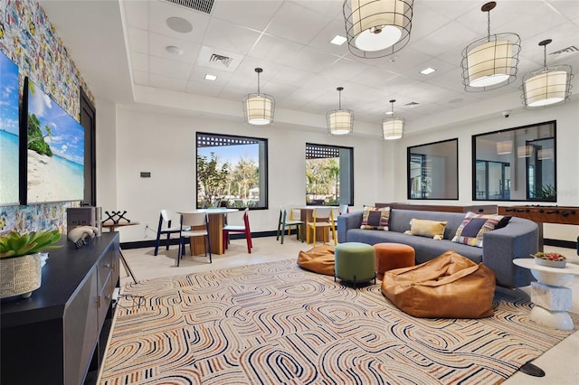 living area featuring visible vents, baseboards, and a drop ceiling