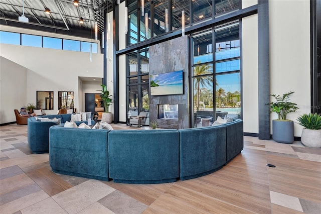 living area with baseboards and a towering ceiling