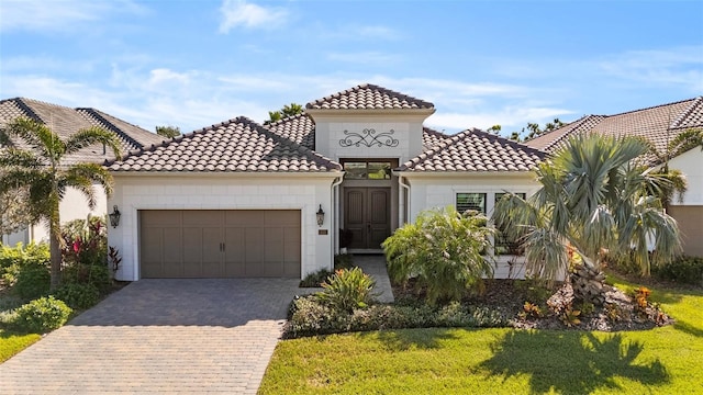 mediterranean / spanish-style house featuring a garage and a front yard