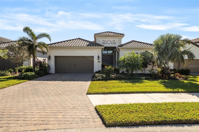 mediterranean / spanish home featuring a front yard and a garage