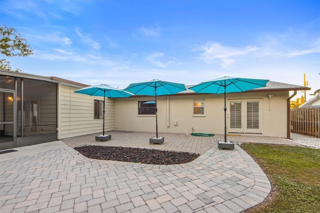 rear view of house featuring a sunroom and a patio