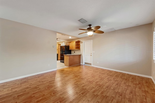 unfurnished living room with light wood-type flooring and ceiling fan