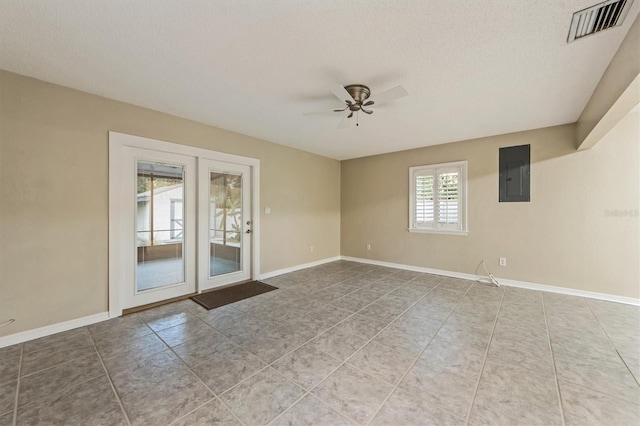 empty room featuring tile patterned floors, electric panel, ceiling fan, and a textured ceiling