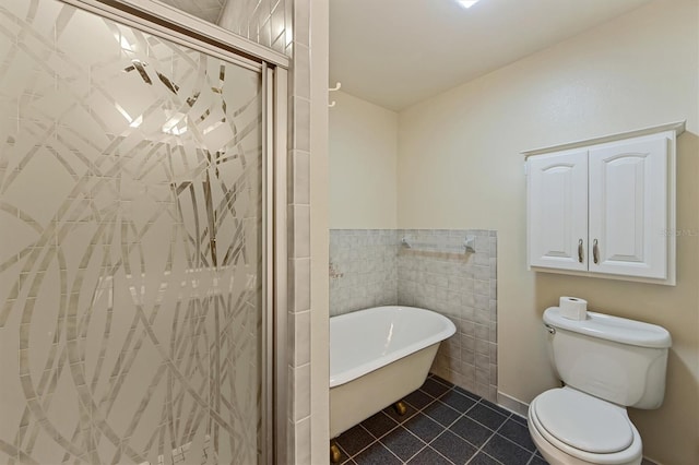 bathroom featuring toilet, tile patterned floors, tile walls, and plus walk in shower