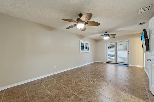 tiled empty room with a textured ceiling and ceiling fan