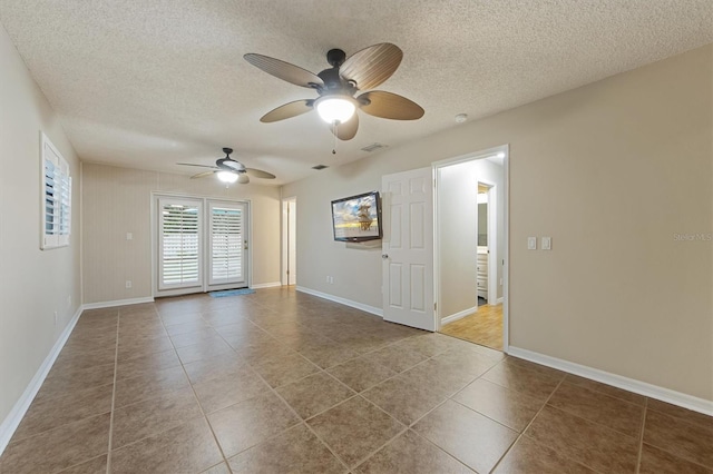 empty room with tile patterned flooring, a textured ceiling, and ceiling fan