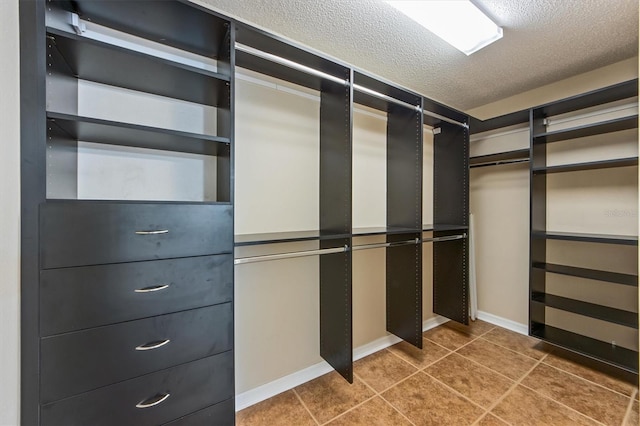 walk in closet with dark tile patterned flooring