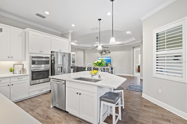 kitchen featuring sink, decorative light fixtures, white cabinets, and appliances with stainless steel finishes