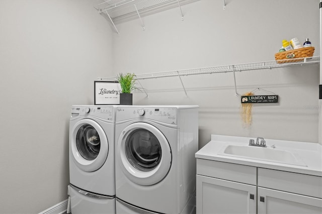 clothes washing area with sink, cabinets, and independent washer and dryer