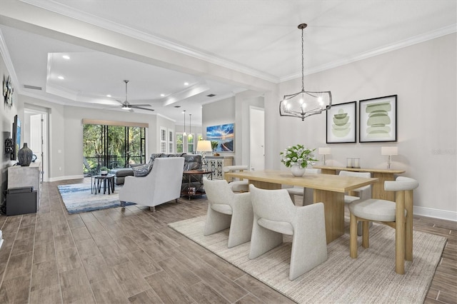 dining room featuring crown molding, a tray ceiling, and wood-type flooring