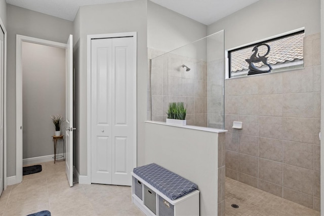 bathroom featuring tiled shower and tile patterned flooring