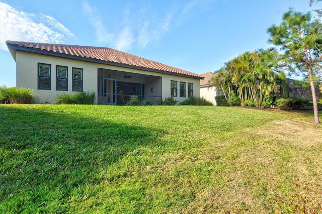 back of property with ceiling fan and a lawn