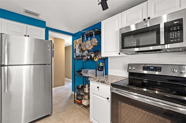 584 Beverly Rd, Venice, FL 34293 - kitchen featuring stainless steel appliances, decorative backsplash, white cabinets, light tile patterned floors, and stone countertops