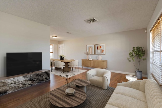 living room featuring dark hardwood / wood-style floors and a textured ceiling