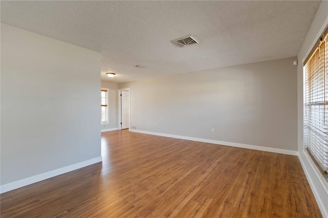 unfurnished room featuring hardwood / wood-style floors and a textured ceiling