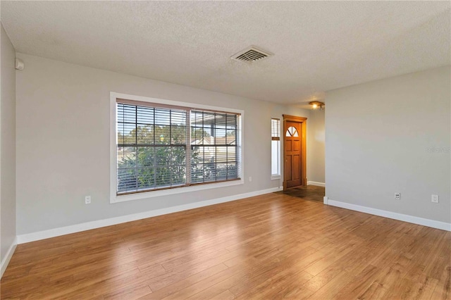 unfurnished room featuring hardwood / wood-style floors and a textured ceiling