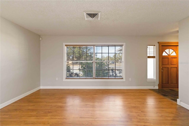 foyer entrance featuring light hardwood / wood-style floors and a textured ceiling