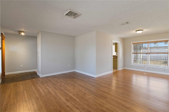 unfurnished room featuring wood-type flooring and a textured ceiling