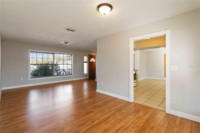 empty room featuring light hardwood / wood-style floors and a textured ceiling