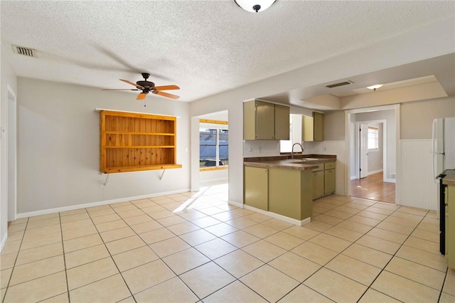 kitchen featuring sink, a textured ceiling, ceiling fan, and light tile patterned flooring