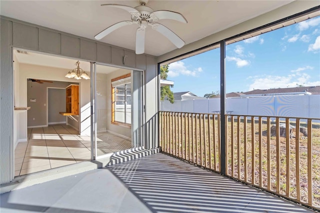 sunroom / solarium with ceiling fan with notable chandelier