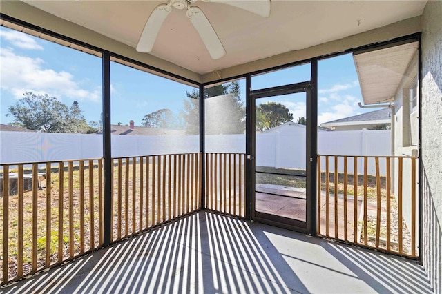 unfurnished sunroom with ceiling fan