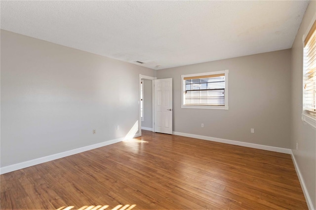 spare room with wood-type flooring and a textured ceiling