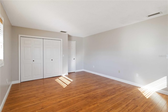 unfurnished bedroom featuring wood-type flooring and a closet