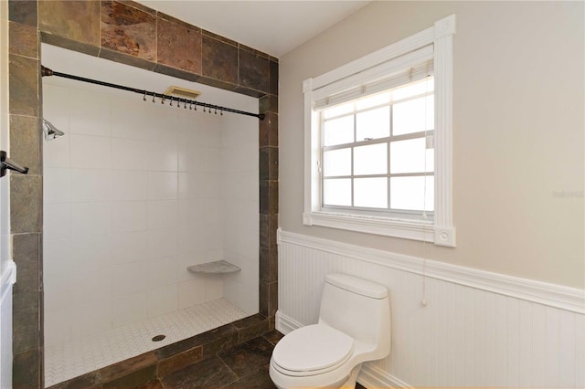 bathroom with tiled shower and toilet