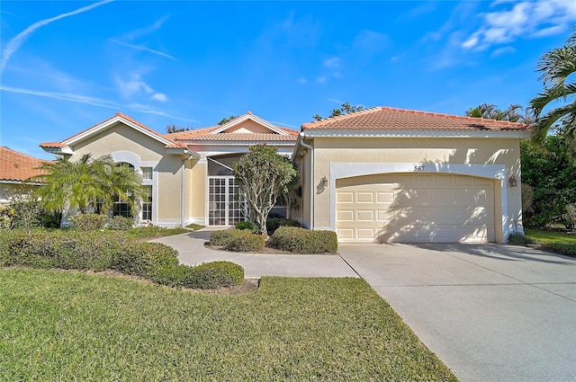 mediterranean / spanish house with a front yard and a garage