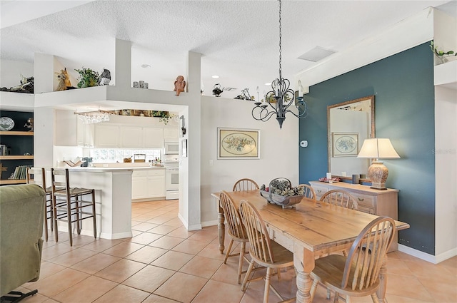 tiled dining space with a textured ceiling and an inviting chandelier