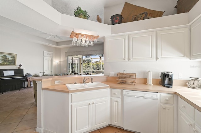 kitchen with kitchen peninsula, sink, dishwasher, white cabinetry, and light tile patterned flooring