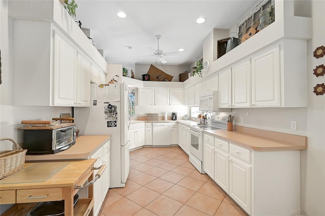 kitchen featuring light tile patterned floors, white appliances, white cabinetry, and ceiling fan