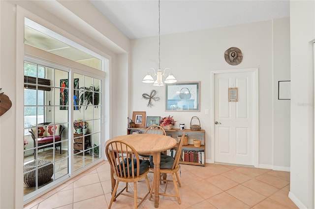 dining space featuring a notable chandelier, light tile patterned flooring, and vaulted ceiling