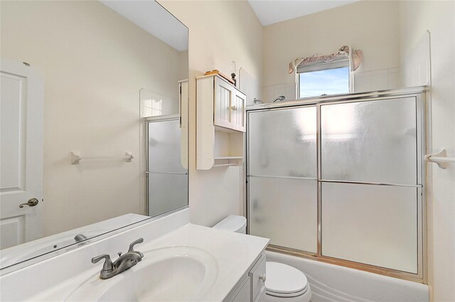 full bathroom featuring shower / bath combination with glass door, vanity, and toilet