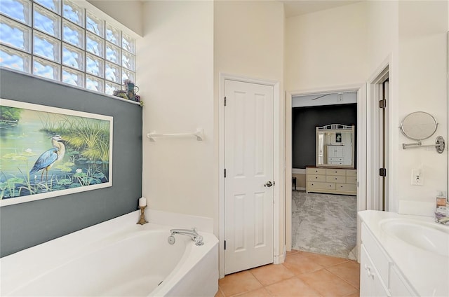 bathroom with tile patterned floors, vanity, and a bath