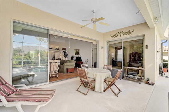 sunroom with ceiling fan and a mountain view