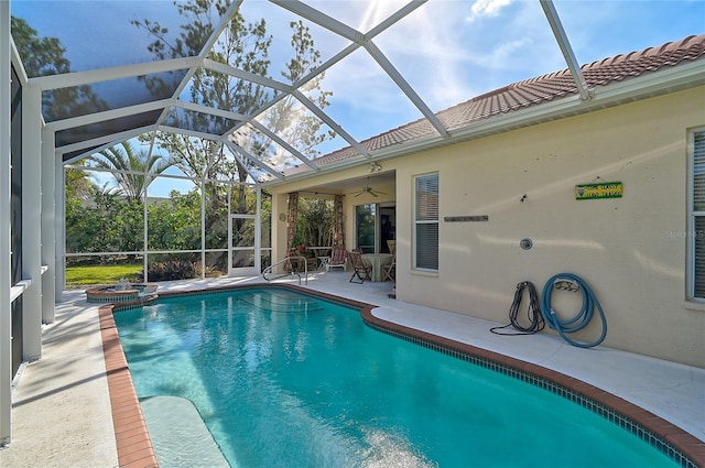 view of swimming pool featuring a patio area, ceiling fan, and glass enclosure