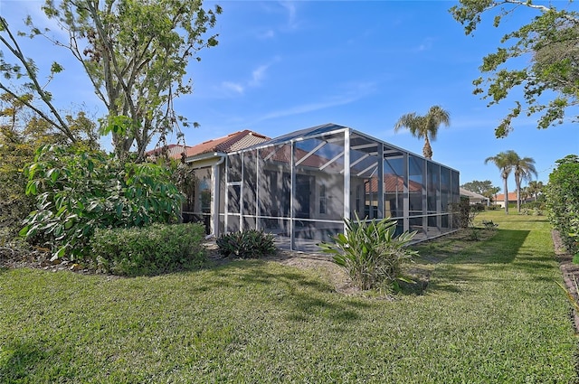 back of property with a lanai and a lawn