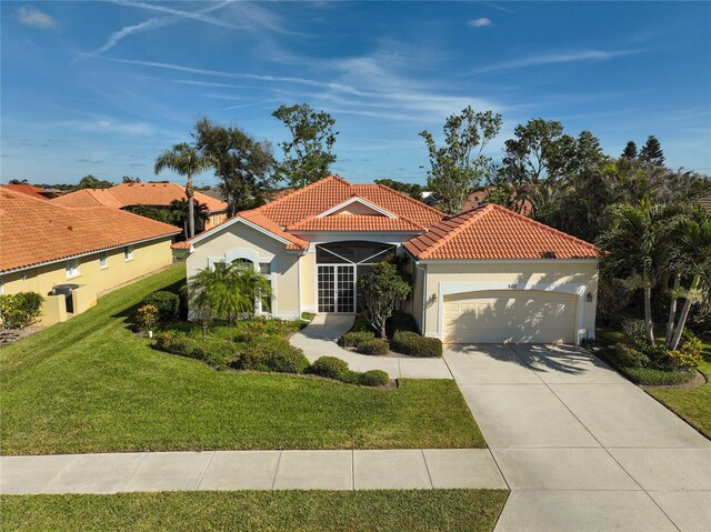 mediterranean / spanish home featuring a front yard and a garage