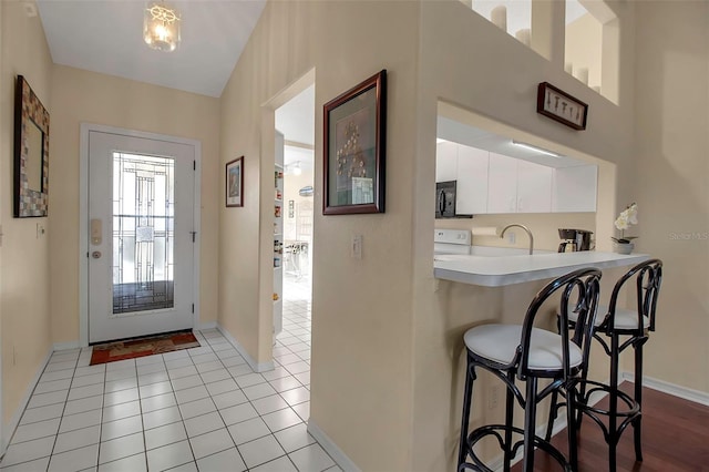 foyer entrance with light tile patterned flooring and sink