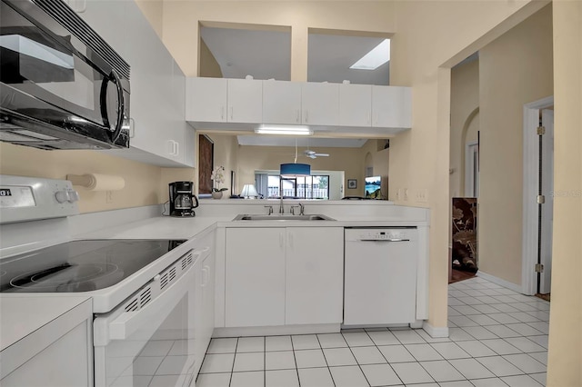 kitchen with white cabinets, white appliances, sink, and light tile patterned floors